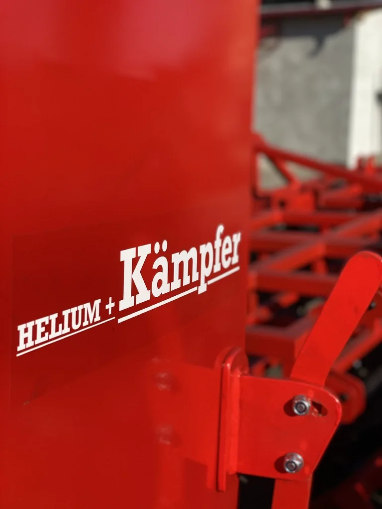 Detaliu logo Helium Kämpfer pe utilaj rosu